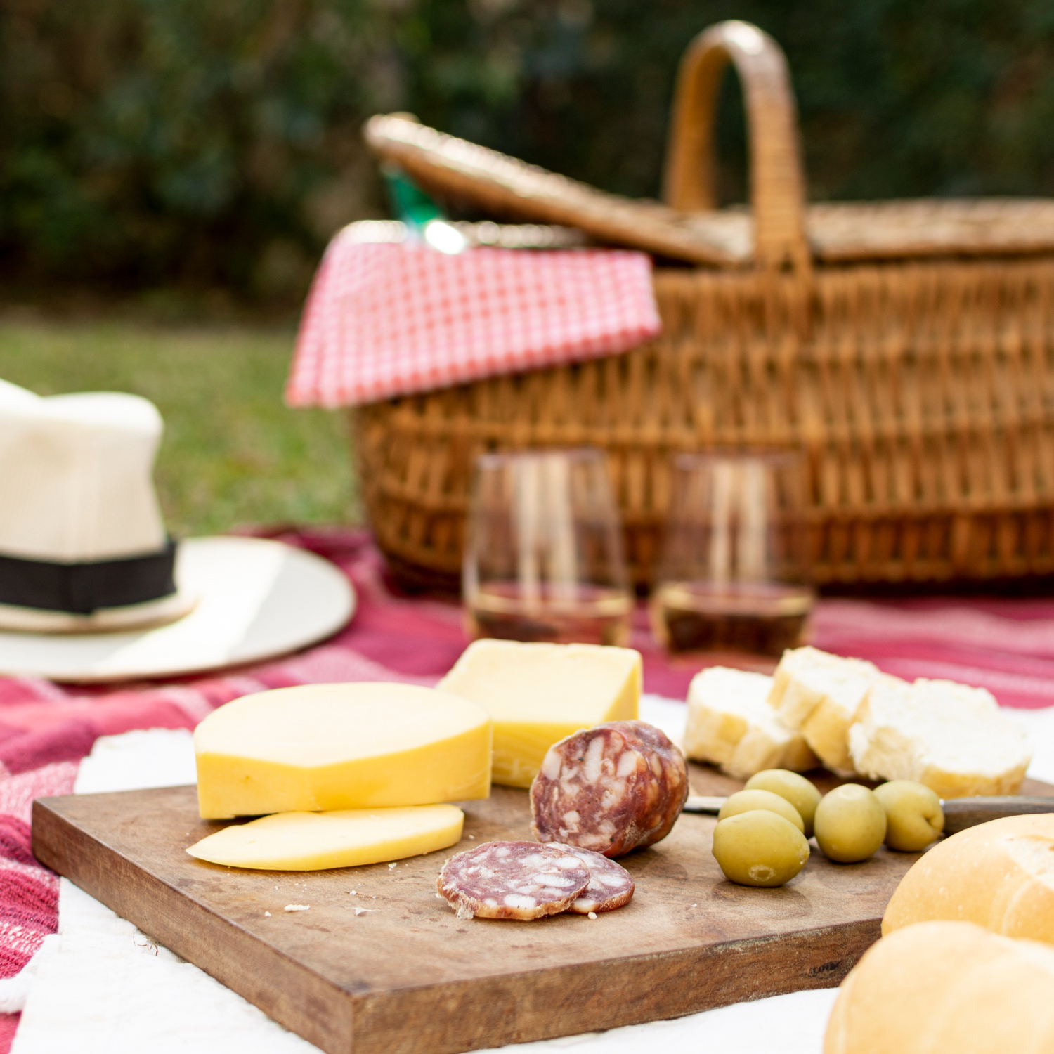 Pique-nique champêtre chez-basta à muret avec charcuterie, fromage, pain et verres de vin blanc
