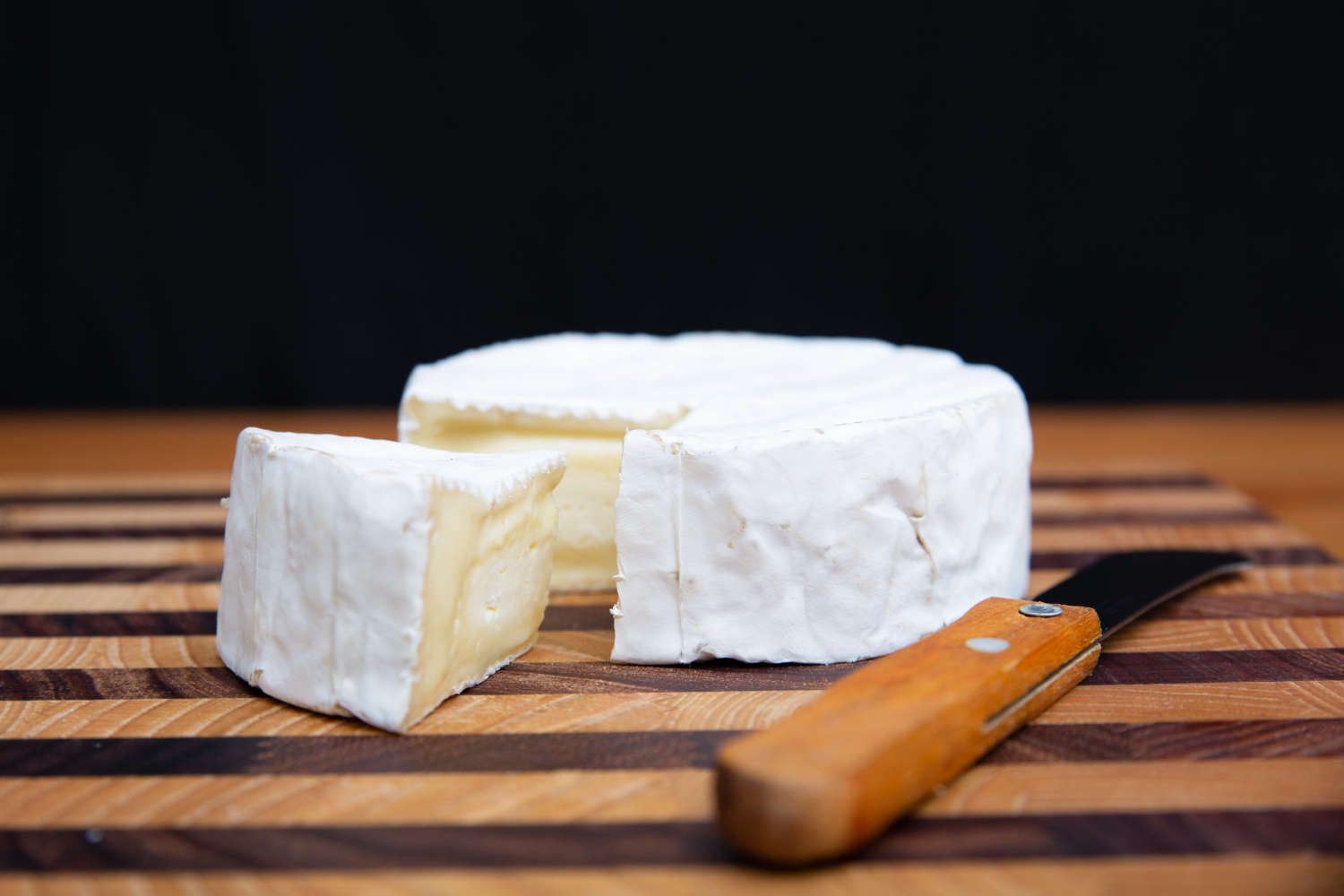 Fromage Brie crémeux sur planche en bois chez-basta à muret, prêt pour la dégustation gourmande