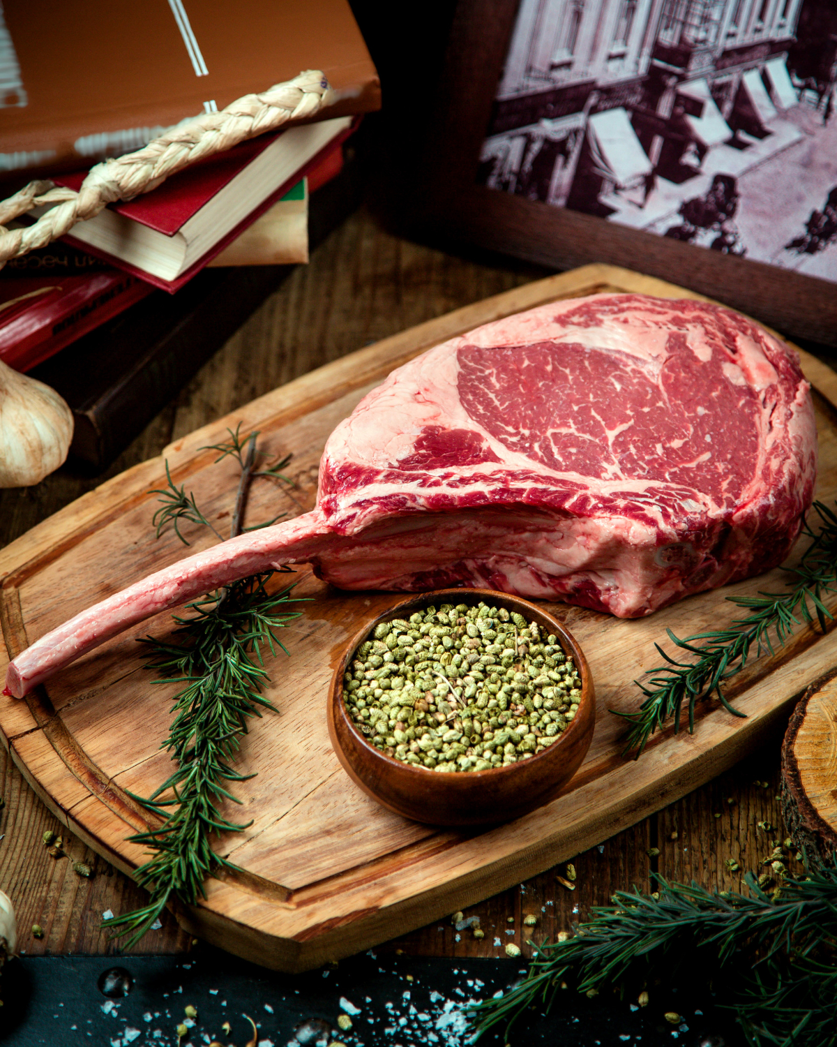 Tomahawk de bœuf cru avec romarin sur planche en bois chez-basta à muret, ambiance rustique et chaleureuse