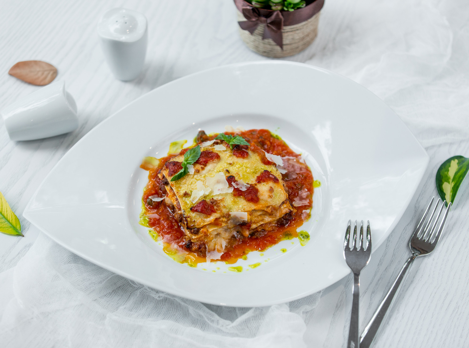 Lasagne maison généreuse au basilic et parmesan chez-basta, table raffinée à muret